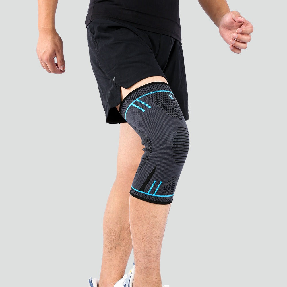 Person wearing a black knee brace with blue accents on a gray background